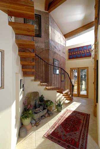 An interior wooden staircase within the entry space of a Poured Earth home in Prescott, AZ